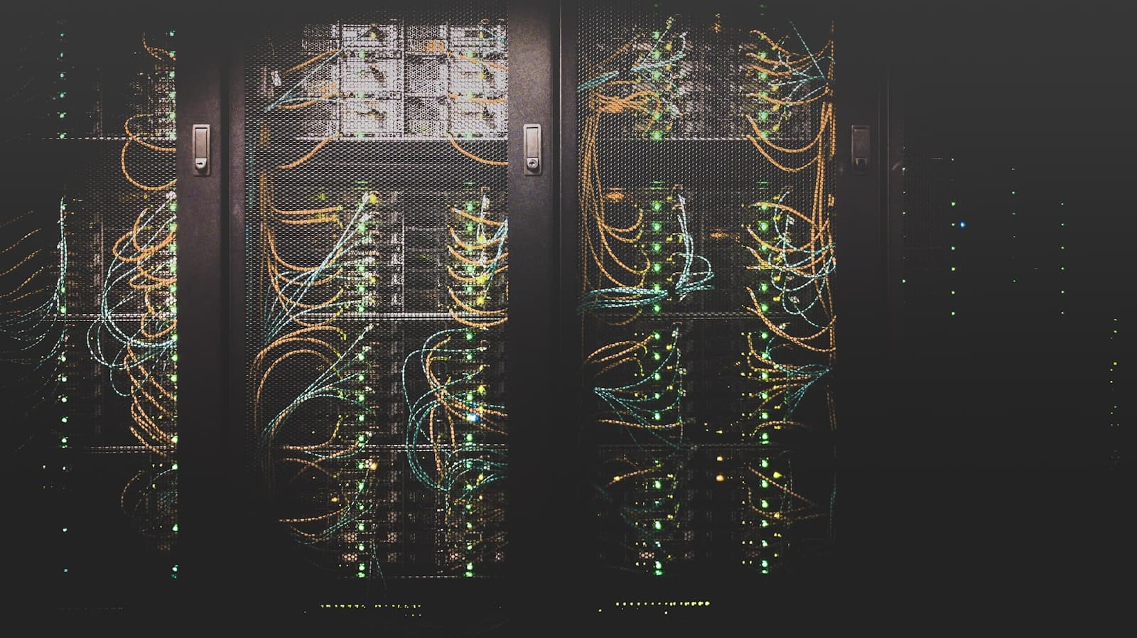 Blue-lit network cables running through a row of server racks